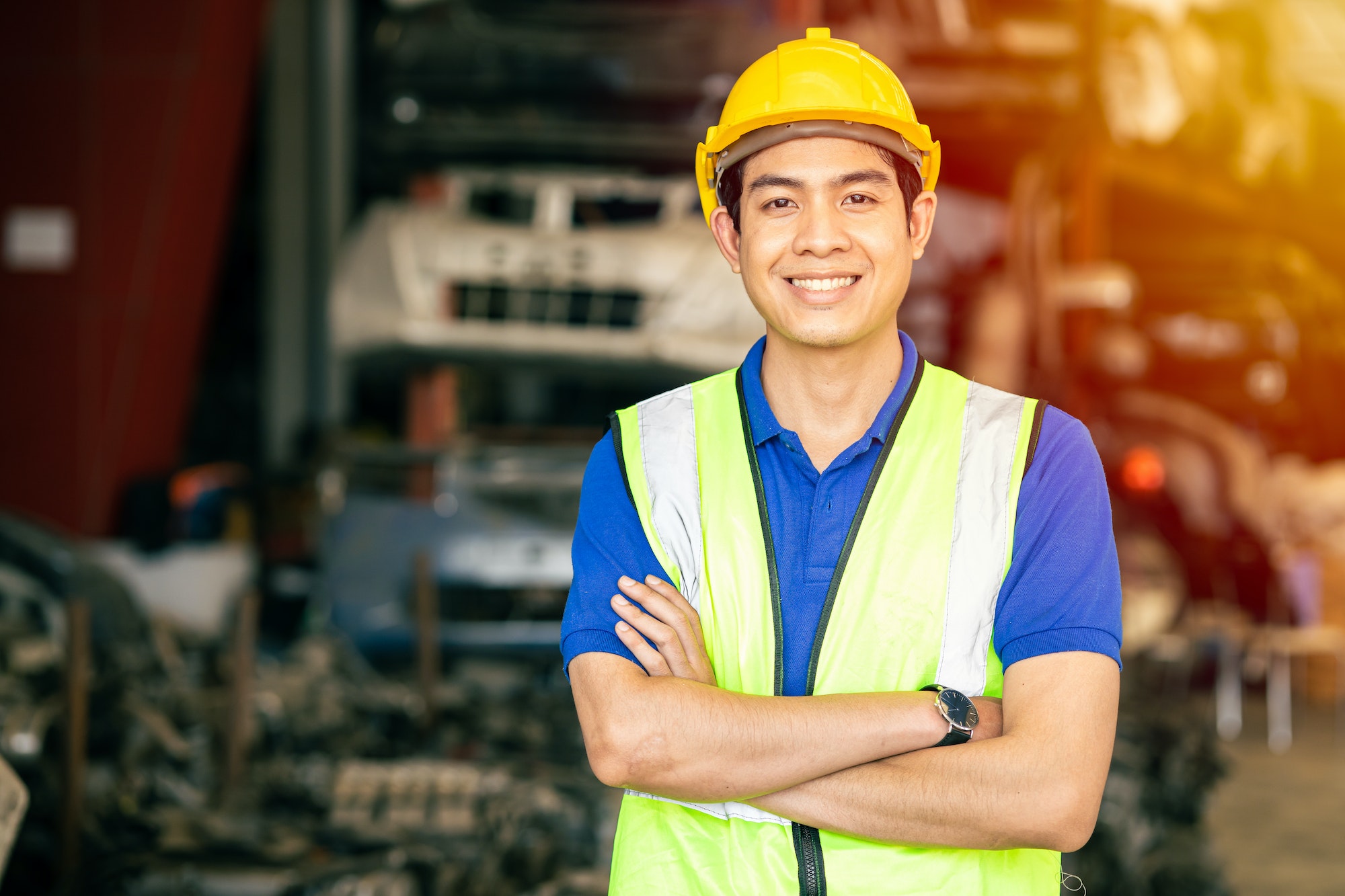Asian male engineer worker standing arm crossed confident happy smile for enjoy working in factory